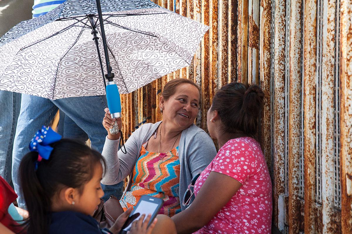 A family at the border fence at Playas de Tijuana, Mexico. A family visits their relative on the...