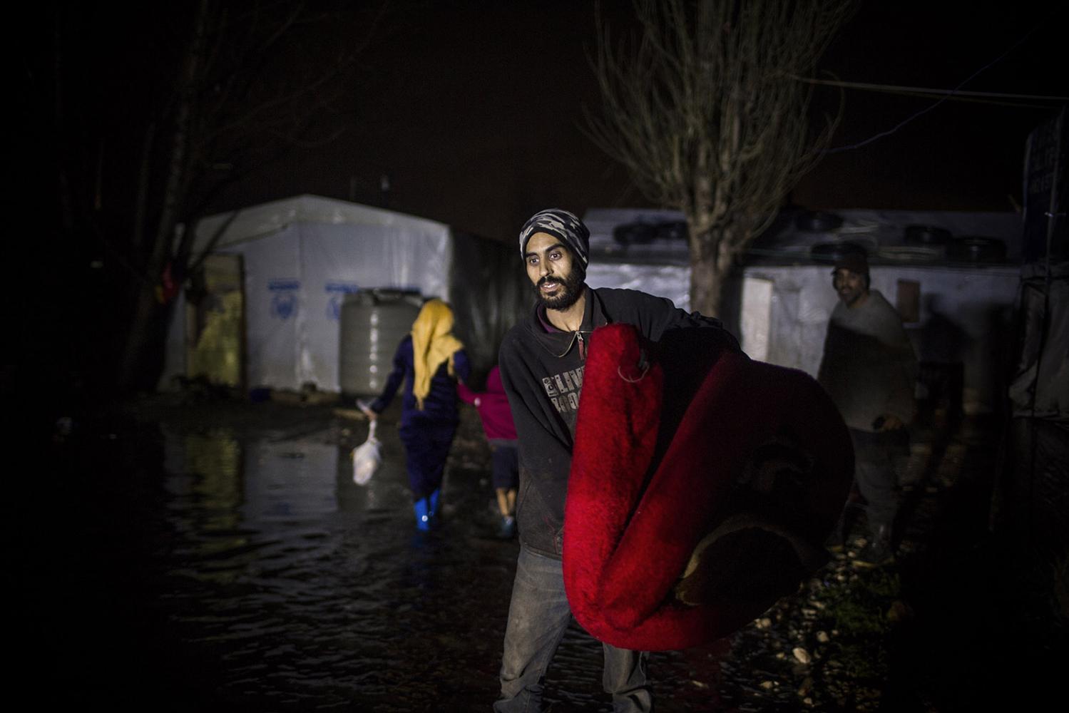 Storm - a Syrian refugee is seen leaving his flooded home at Bar...