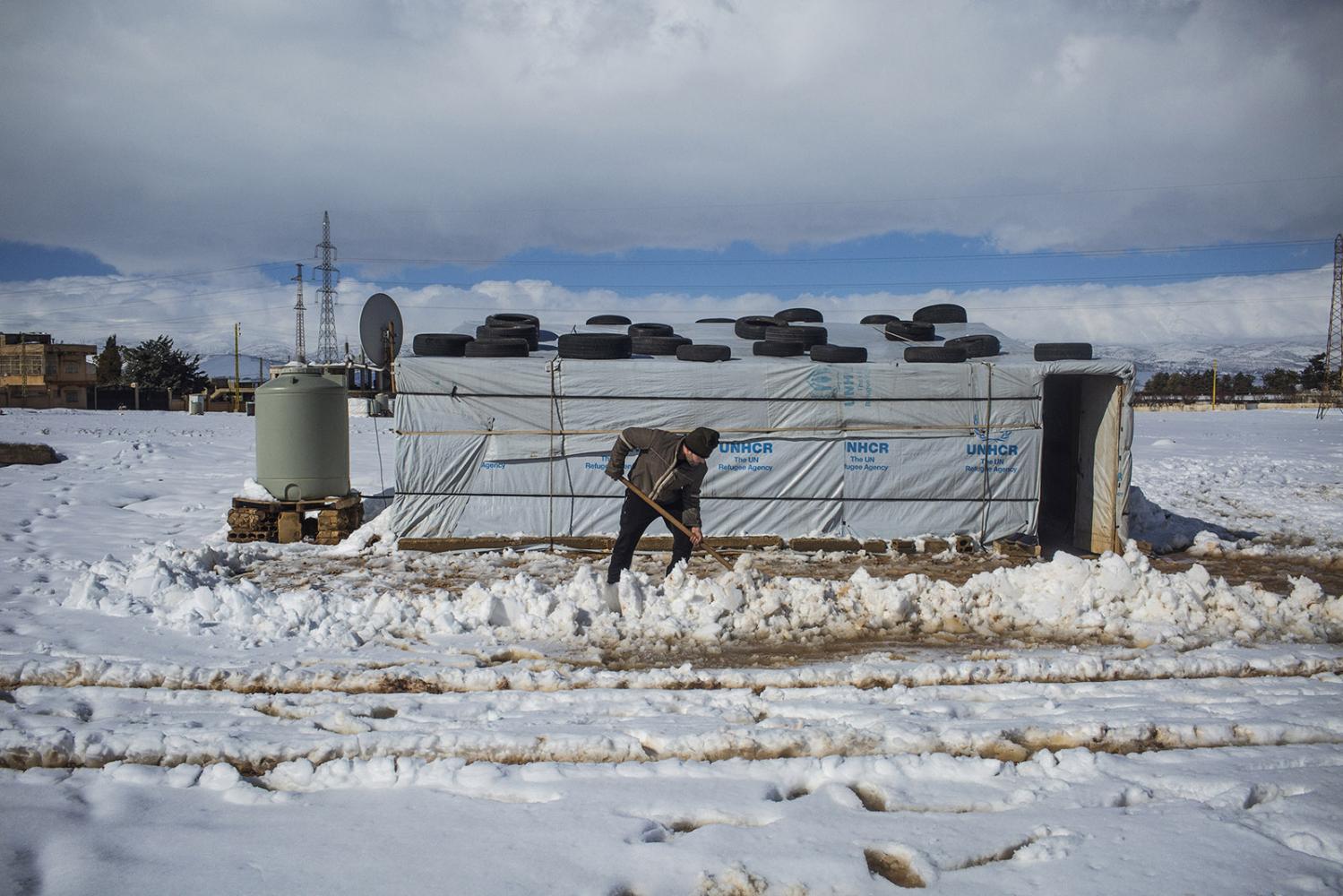 Storm - Ahmed ,a Syrian refugee from Raqqa, removes snow with a...
