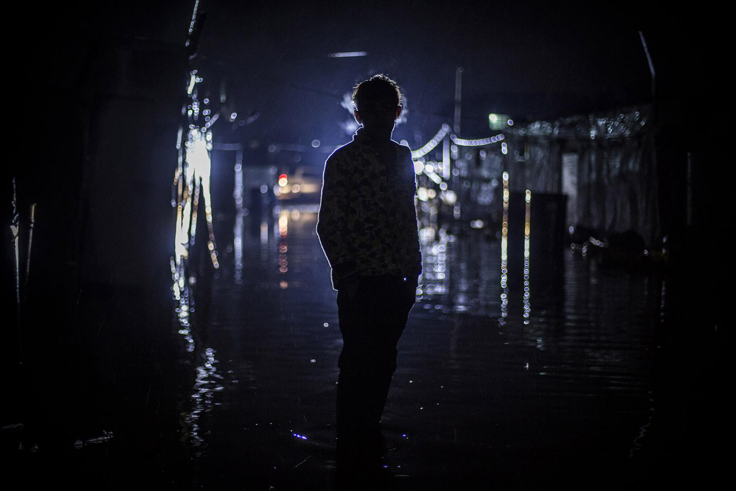 Storm - A Syrian refugee stands at the flooded streets at the...