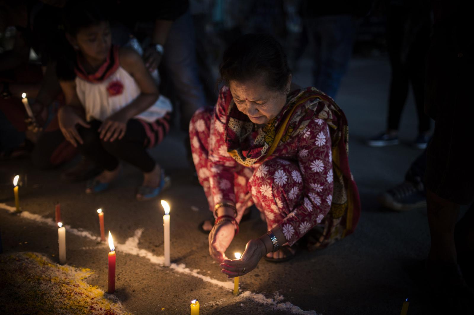 Nepal: Aftermath - Nepalese people light candles during a candlelight vigil...