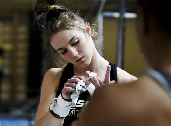 Image from Sports - MU senior Morgan Porter places her grips before...