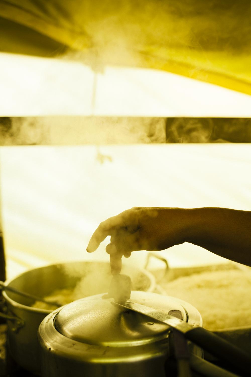 The hand of a woman who preferred not to be identified releases the steam from a pressure pot. Soup kitchens are another form of organization within the MTST organization that manages to feed their adherents with food and supplies coming from other empty lands turned into farms, taken across the country. Itaquera, S&atilde;o Paulo / Brazil. 2014.