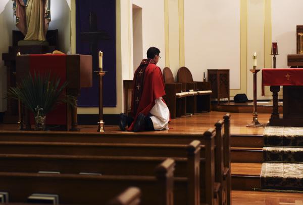 Image from Editorial - Father Francis Doyle kneels before the altar on Sunday,...