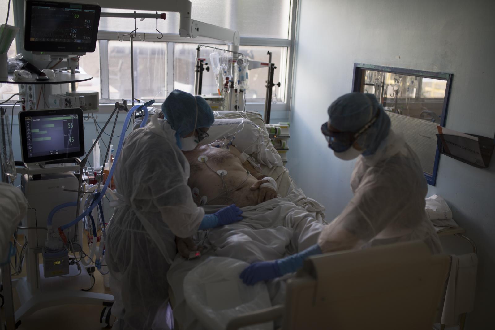 Healthcare workers assist a COV...5, 2020. (AP Photo/Daniel Cole)