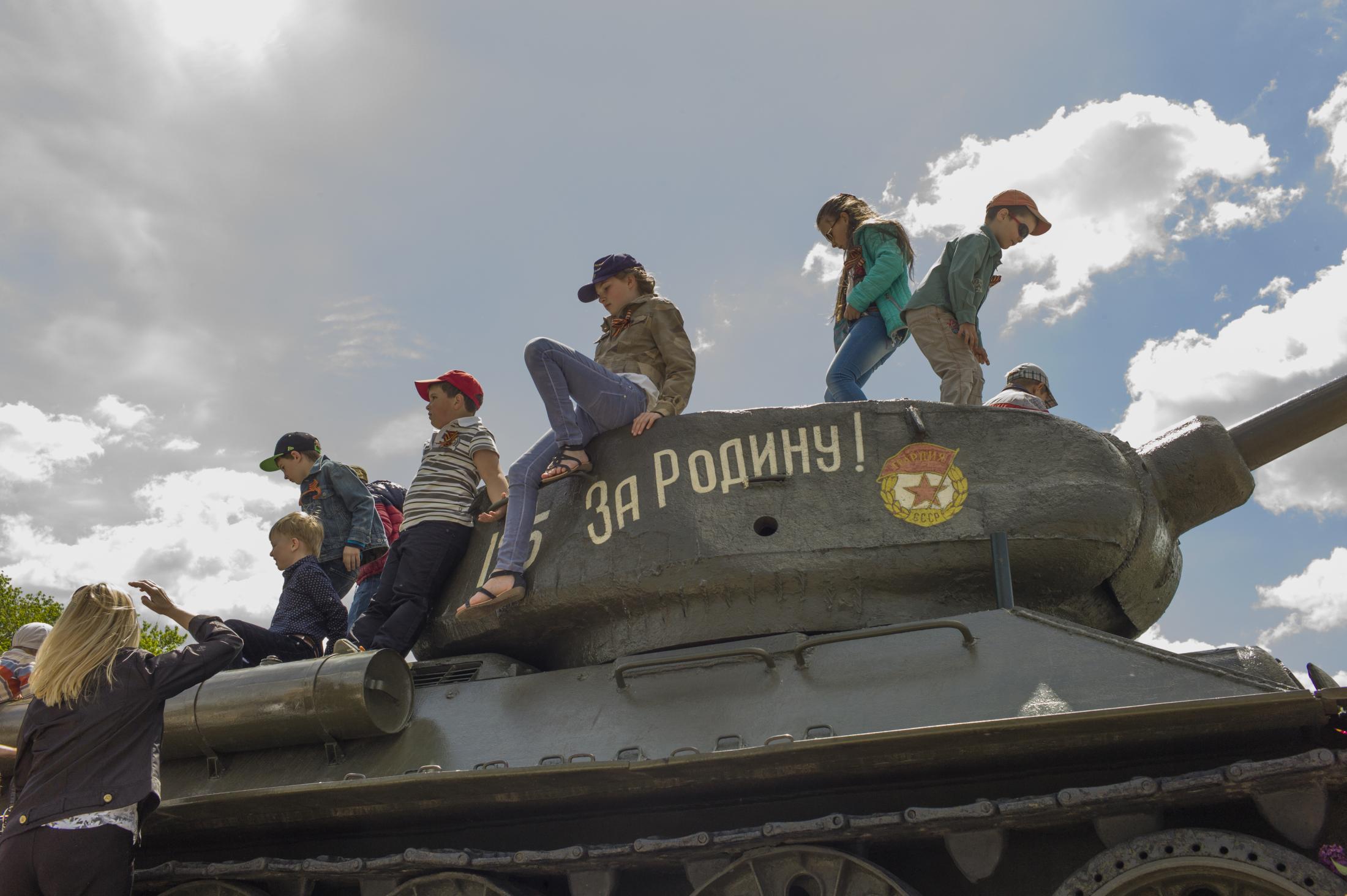  Kids play on the tank, where a sign reads&nbsp; &quot;For the homeland&quot;,...