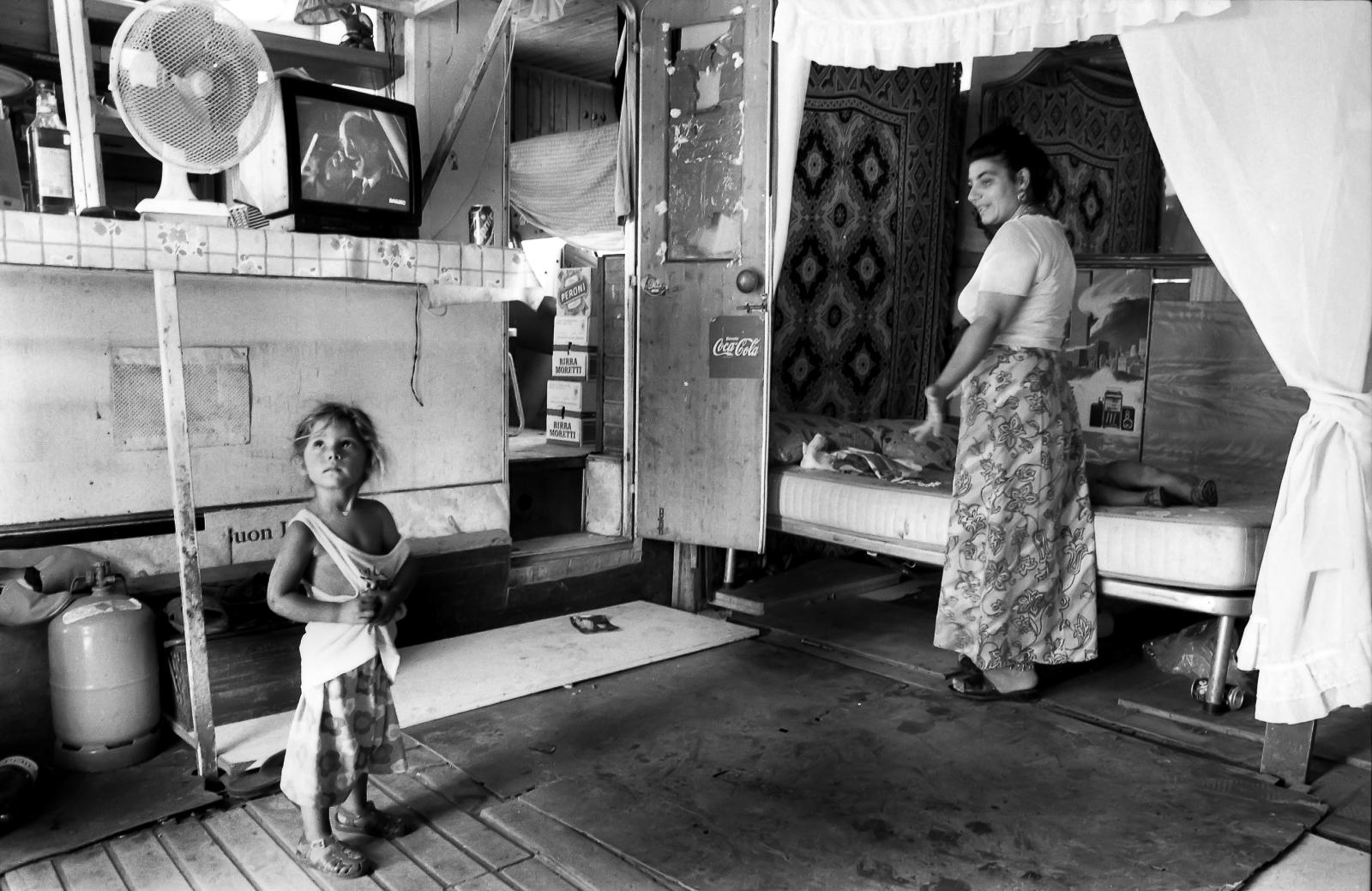 Mother talking to young daughter in gypsy camp in Rome, Italy.