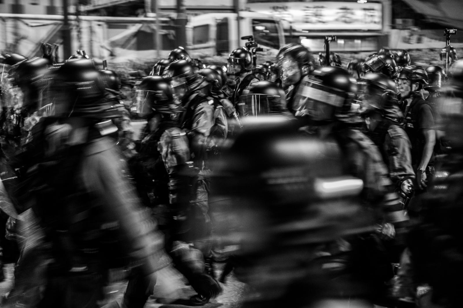 Riot police march along the streets of Hong Kong. Aug 2019.