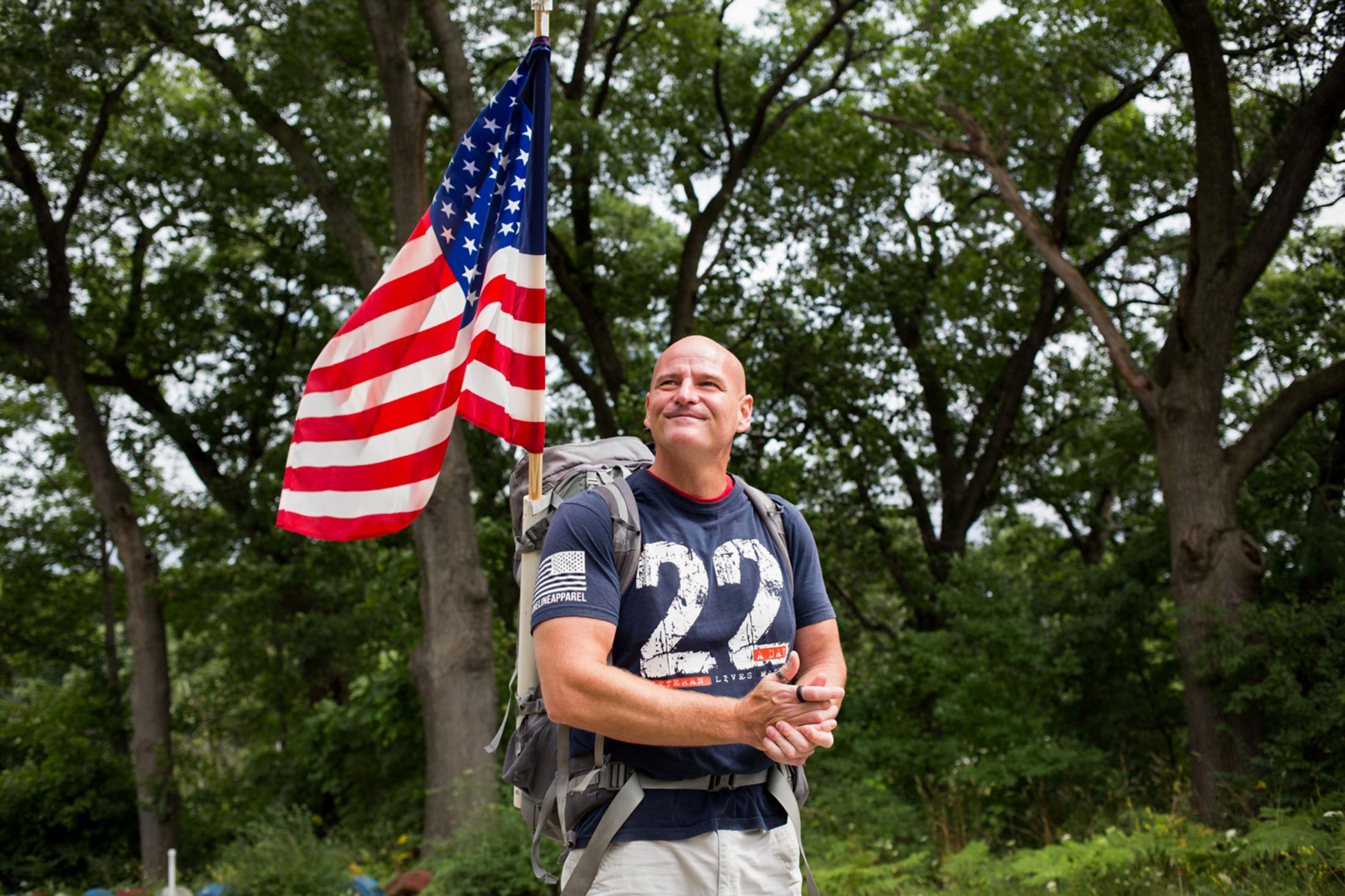 Singles -  Marty Willis, a U.S. veteran, carries an American flag...