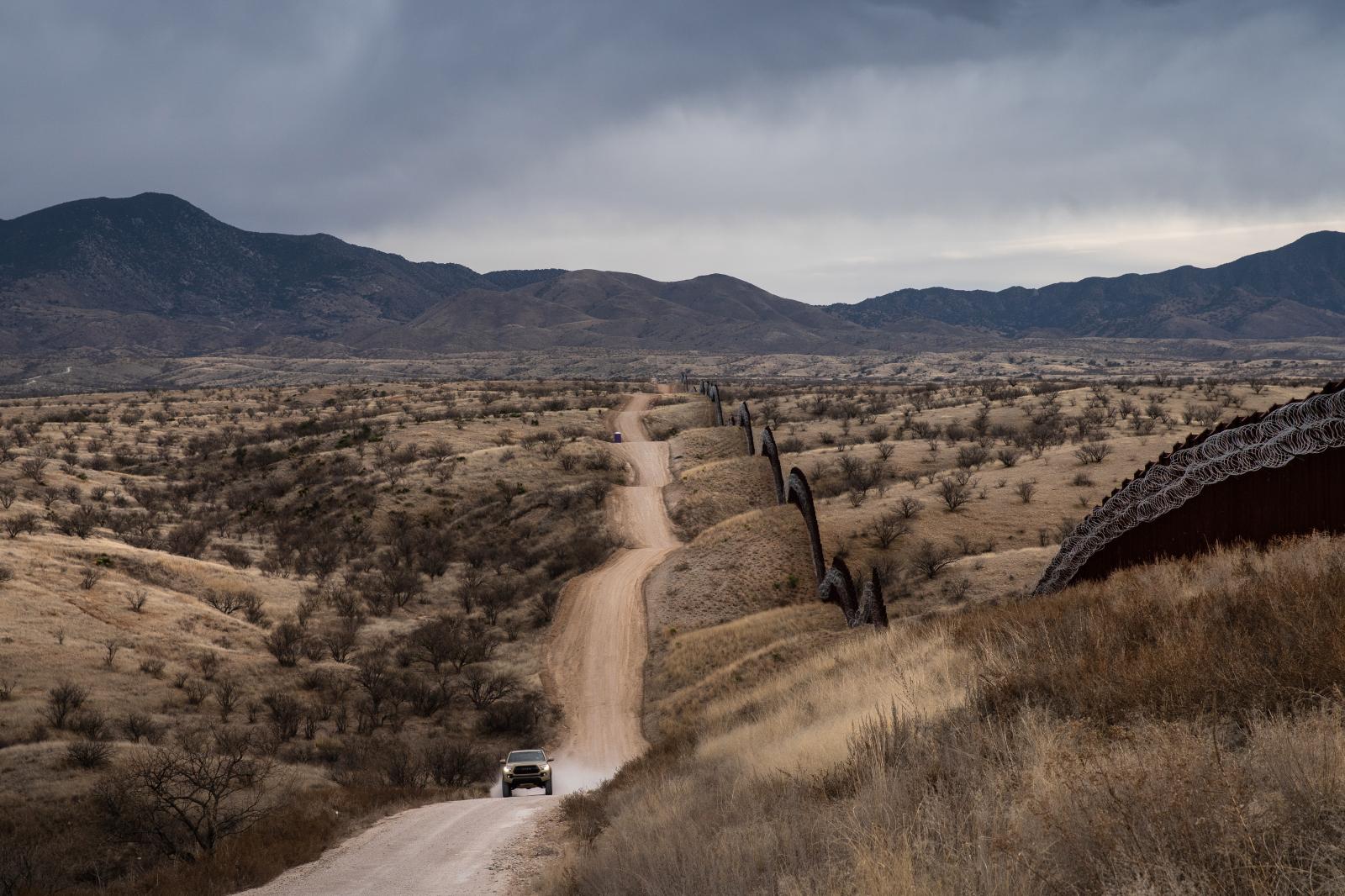 A truck speeds by the US border fence covered in concertina wire separating the US and Mexico, at the outskirts of Nogales, Arizona, on February 9, 2019.