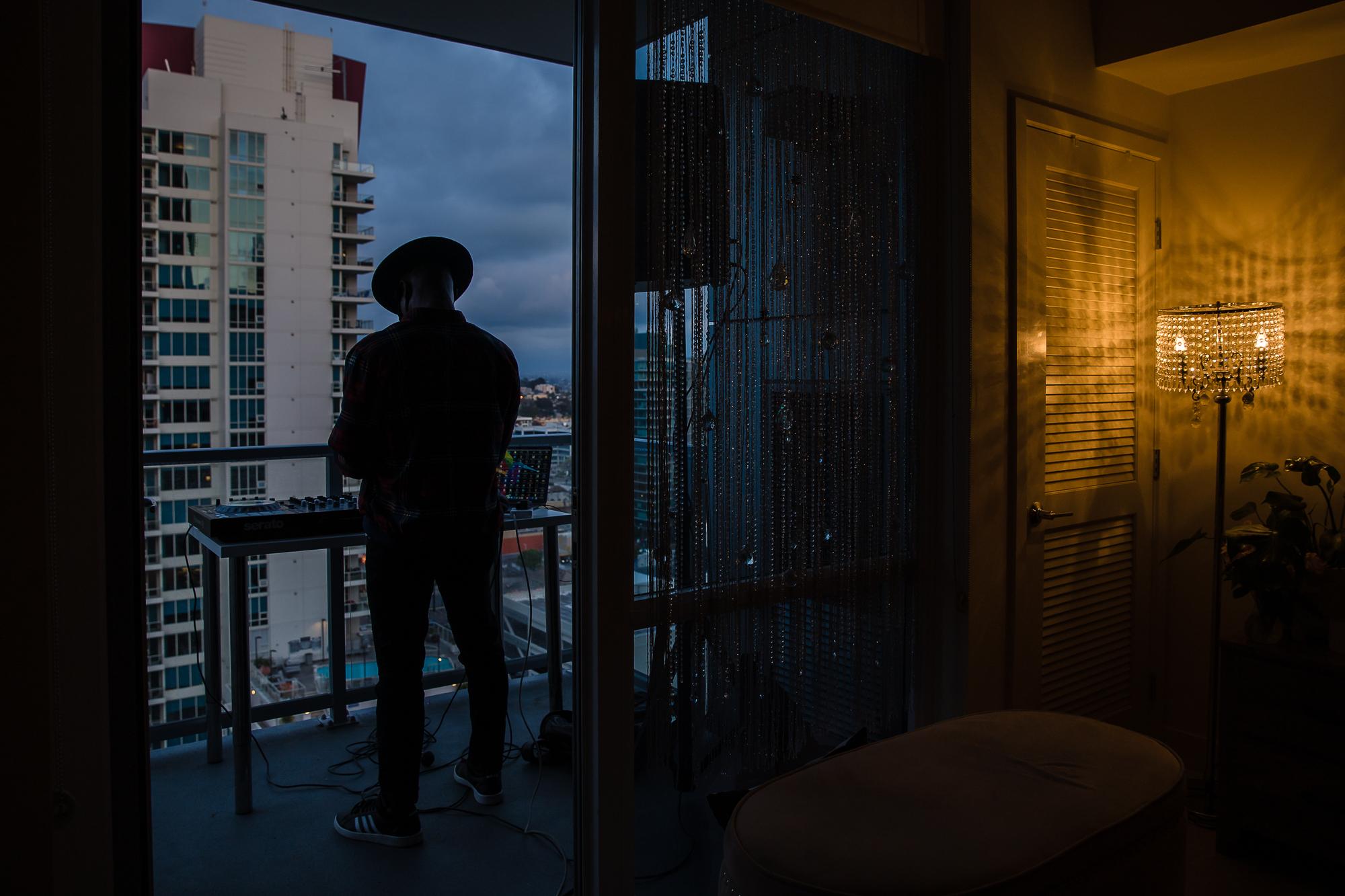 Noel Brandon known as DJ IAMNOEL gets ready to play his set on friend&#39;s a balcony in downtown San Diego on April 11, 2020.