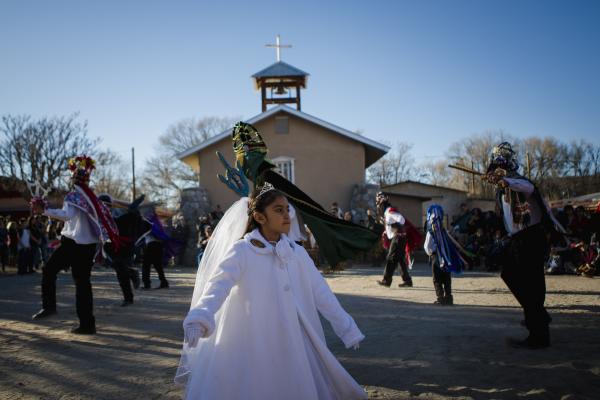 Eight-year-old Brienna Martinez dances with the Los Matachines de Alcalde dancers outside of La Capilla de San Antonio in Alcalde, New Mexico on December 27, 2017. Dressed in all white, she plays the role of La Malinche, who represents purity and the first convert to Christianity in New Spain, Do&ntilde;a Marina.