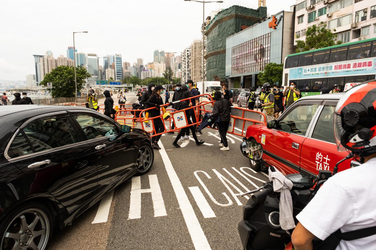 A group of protestors blocks th...ng Island. Hong Kong, May 2020.