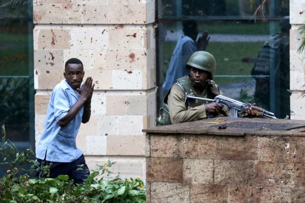 Daniel Irungu | Kenya Nairobi Explosion  - A Kenyan police officer takes cover as he rescues a...