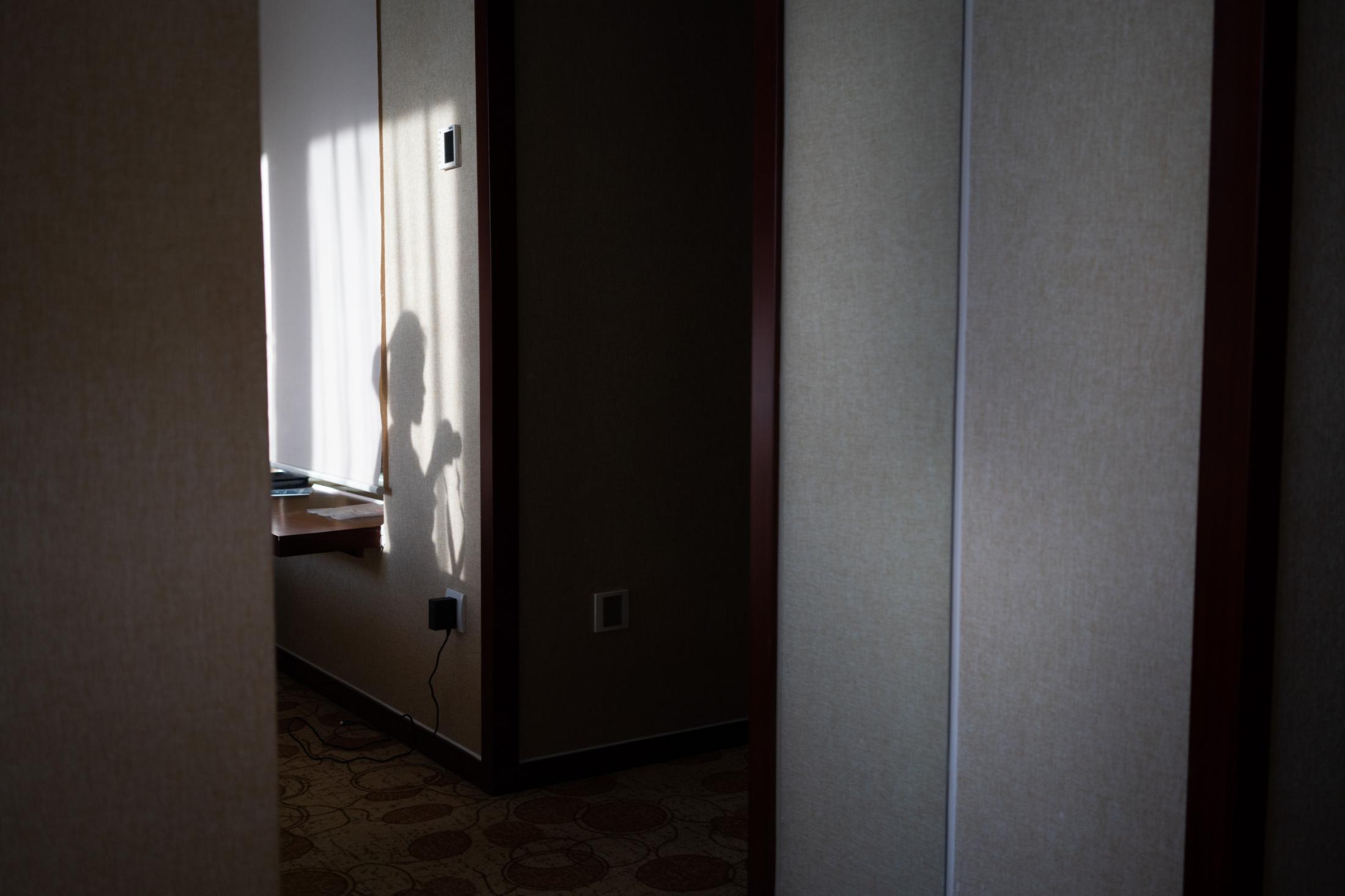Hotel Quarantine through a Peephole - A self-portrait of my shadow during the sunset hours in...