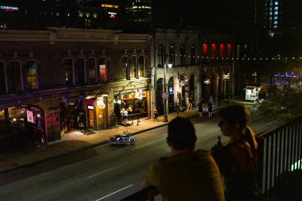 Image from Recent - A couple looks down at Sixth Street from the rooftop of...