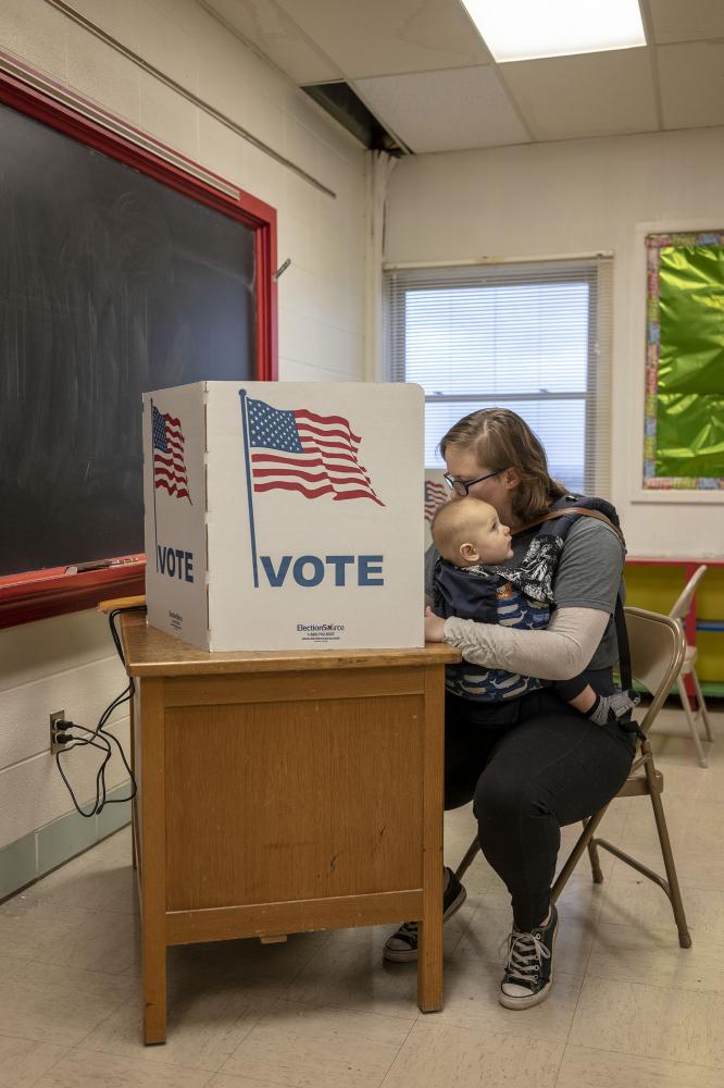 Politics - Katie Wilker of Sherrill, Iowa votes with her son Torin...