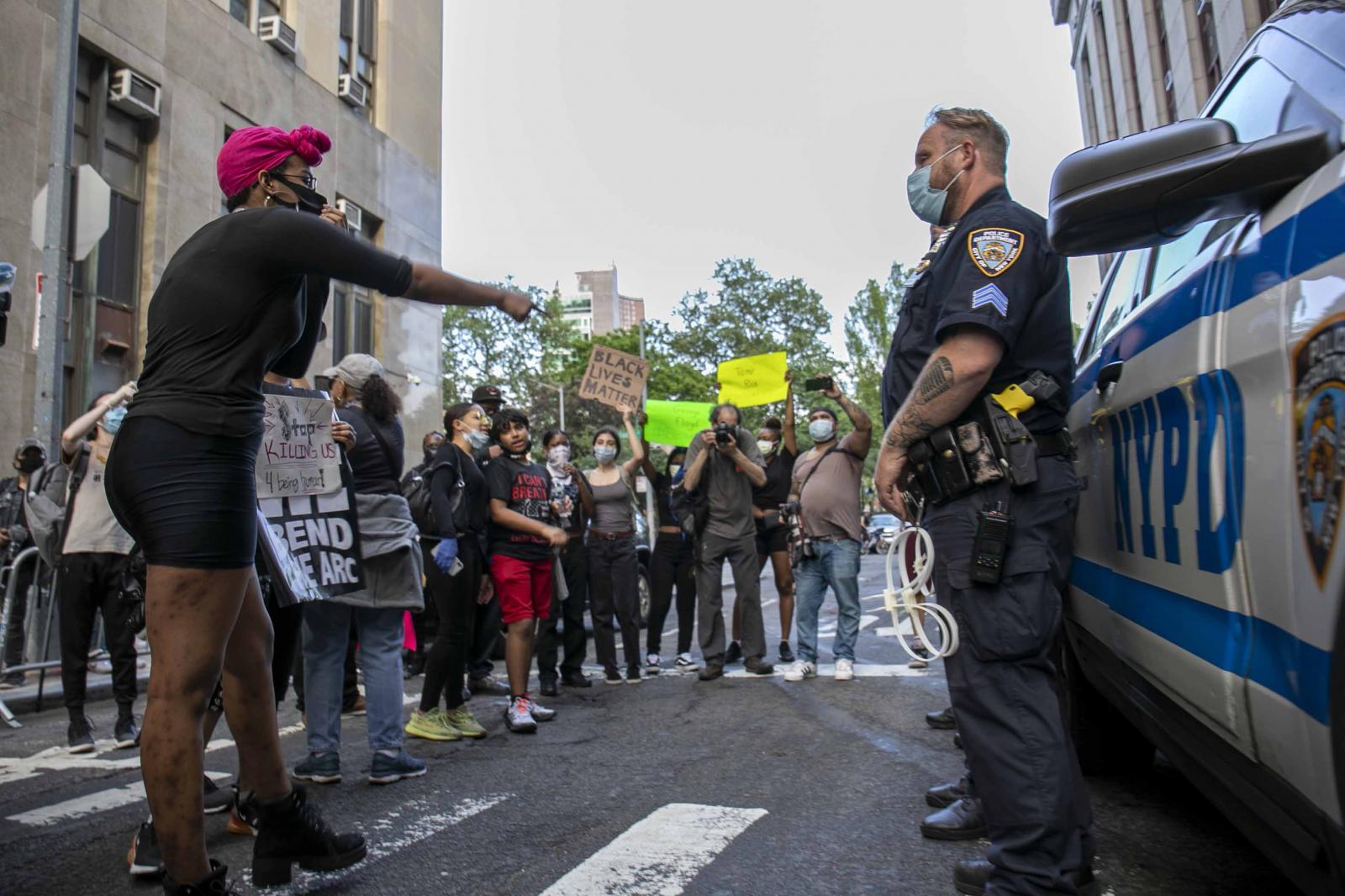 A protestor yells at a NYPD off...ng him her experience as a WOC.