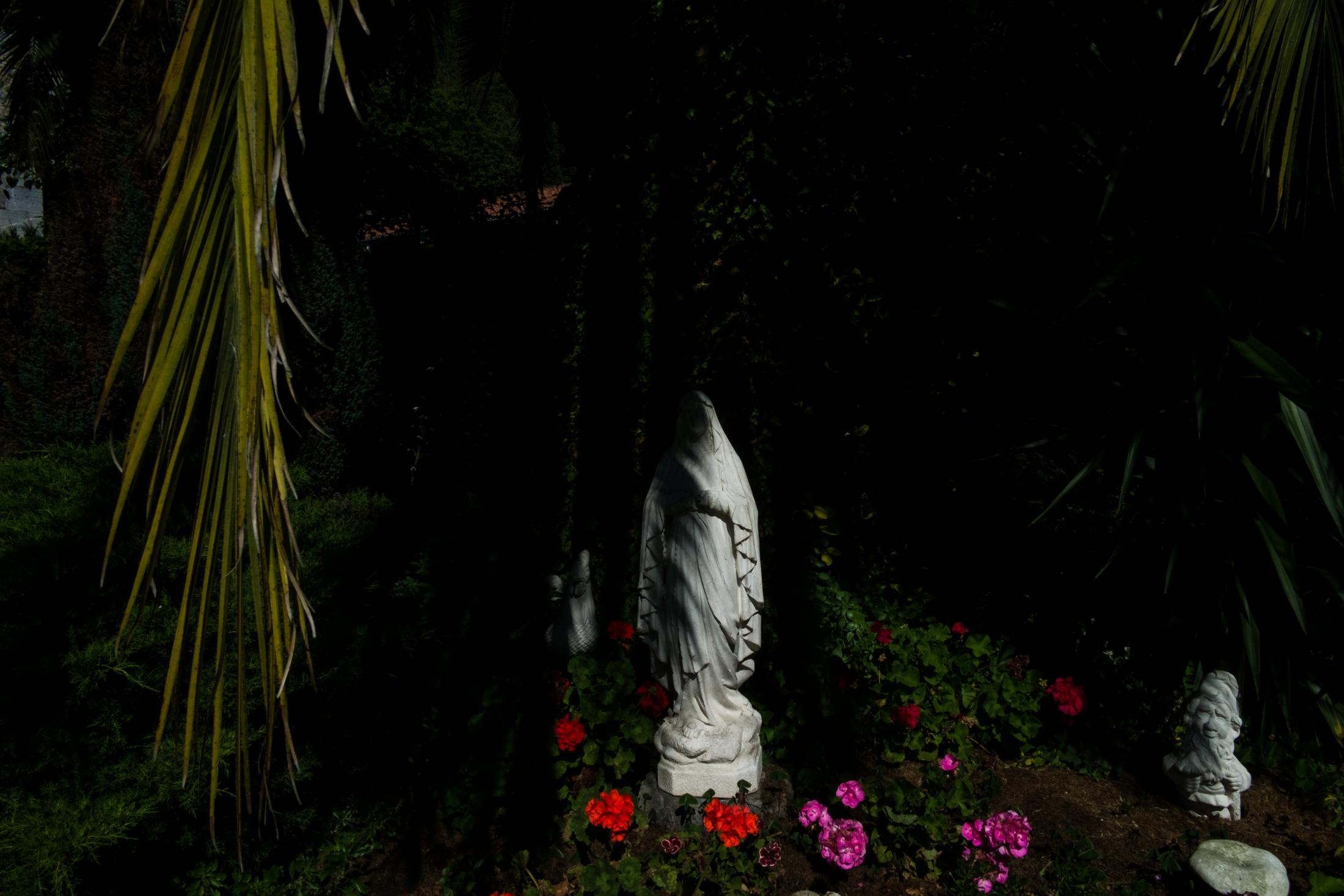 AN OASIS INSIDE THE PANDEMIC -   Statue of Virgin Mary in the courtyard garden of the...