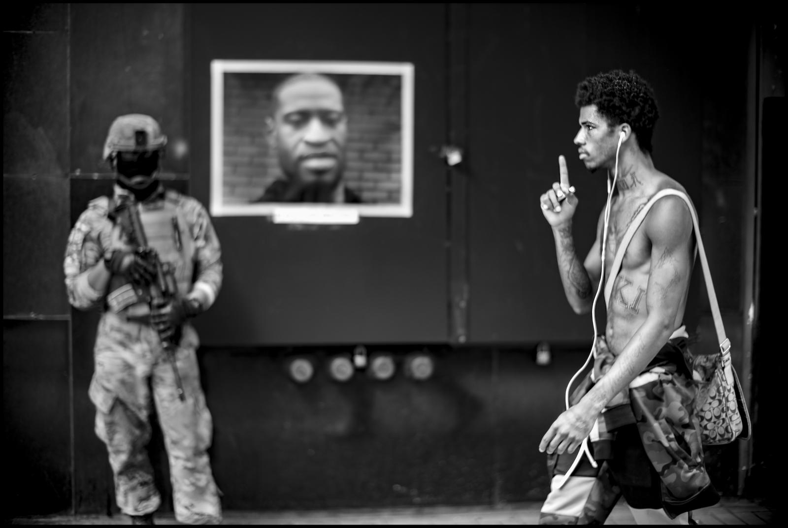  African American male gestures passing U.S. Army soldier Christian Garcia as he guards business, Hill St. downtown Los Angeles, CA. 06/06/2020. 