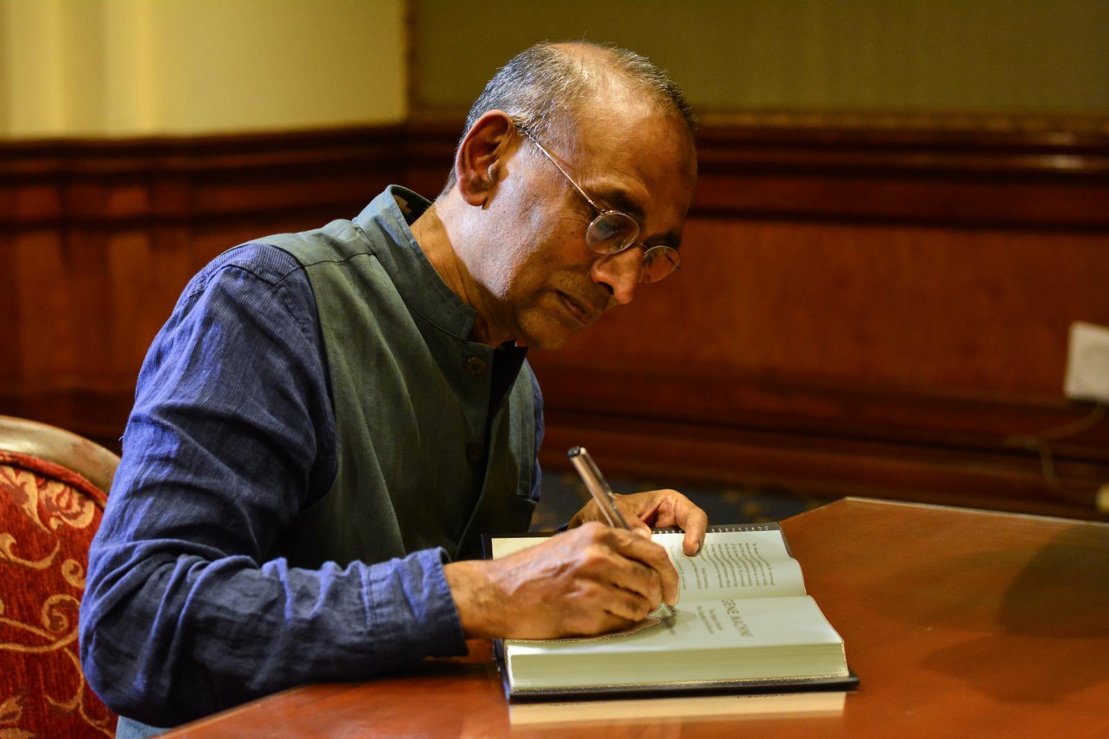 Nobel laureate and scientist Venkatraman Ramakrishnan autographs his book &quot;Gene Machine&quot; at the Leela Palace in Bangalore, where he was invited to address an audience.  