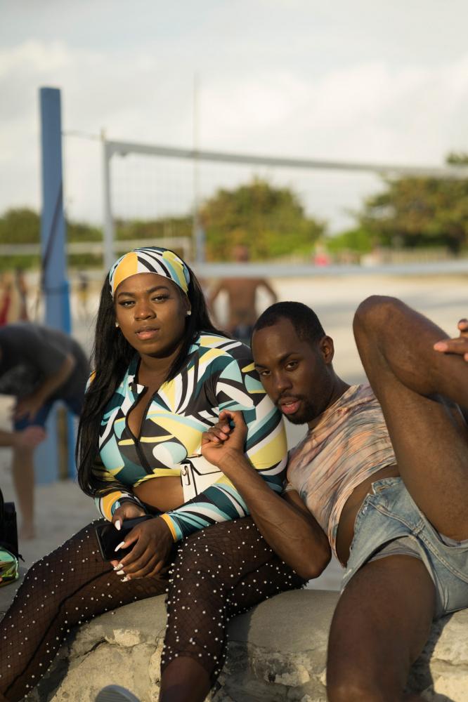 Image from Miami Bites - People react as they hang out sitting on the wall near...