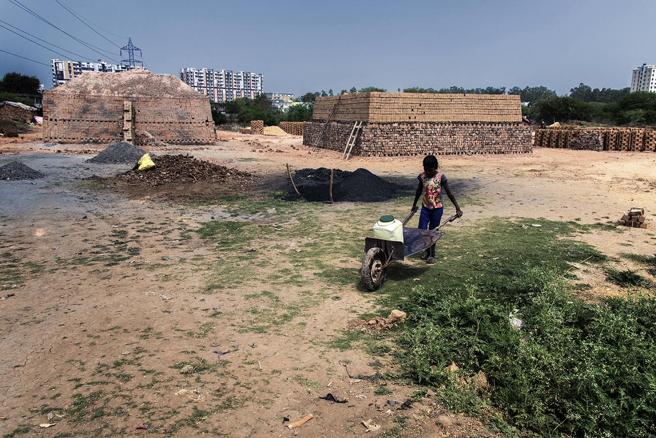 Migrant workers in Bhopal - Children carring water from a distance. She lives in a...