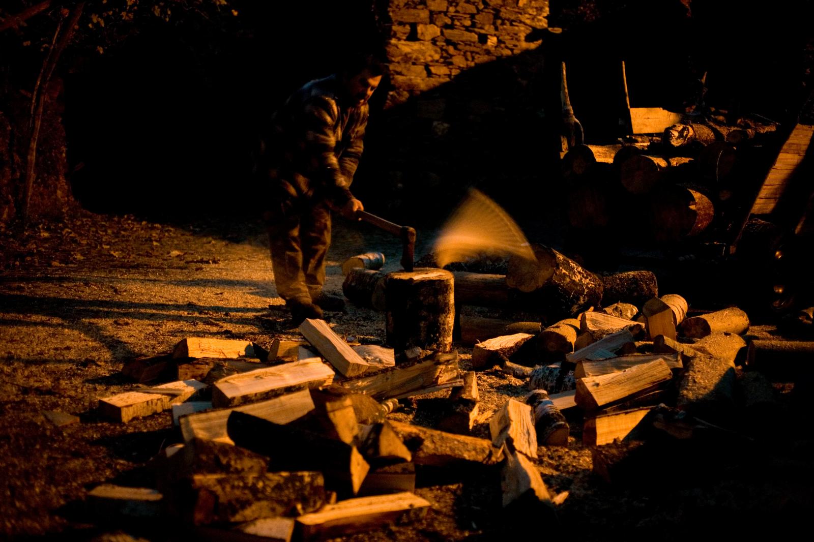 Alfredo Brito, one of the inhabitants chopping wood at night.