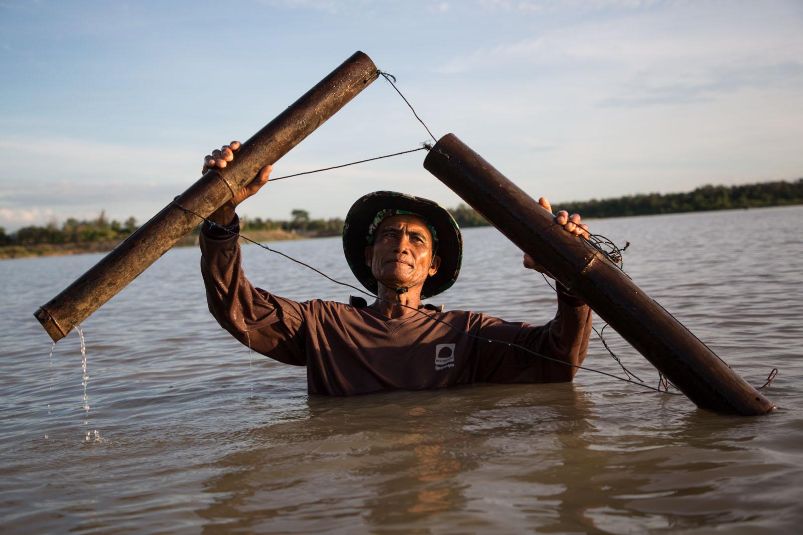 THREE DECADES OF AN ANTI-DAM STRUGGLE - Thongin Nongrak, 63, fishes with a traditional bamboo...