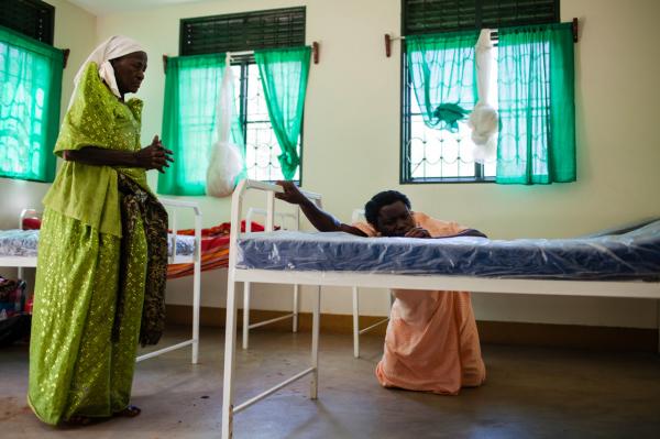 Image from  Esther Mbabazi | The Acquaintance - Masa prays and comforts her patient who is about to give...