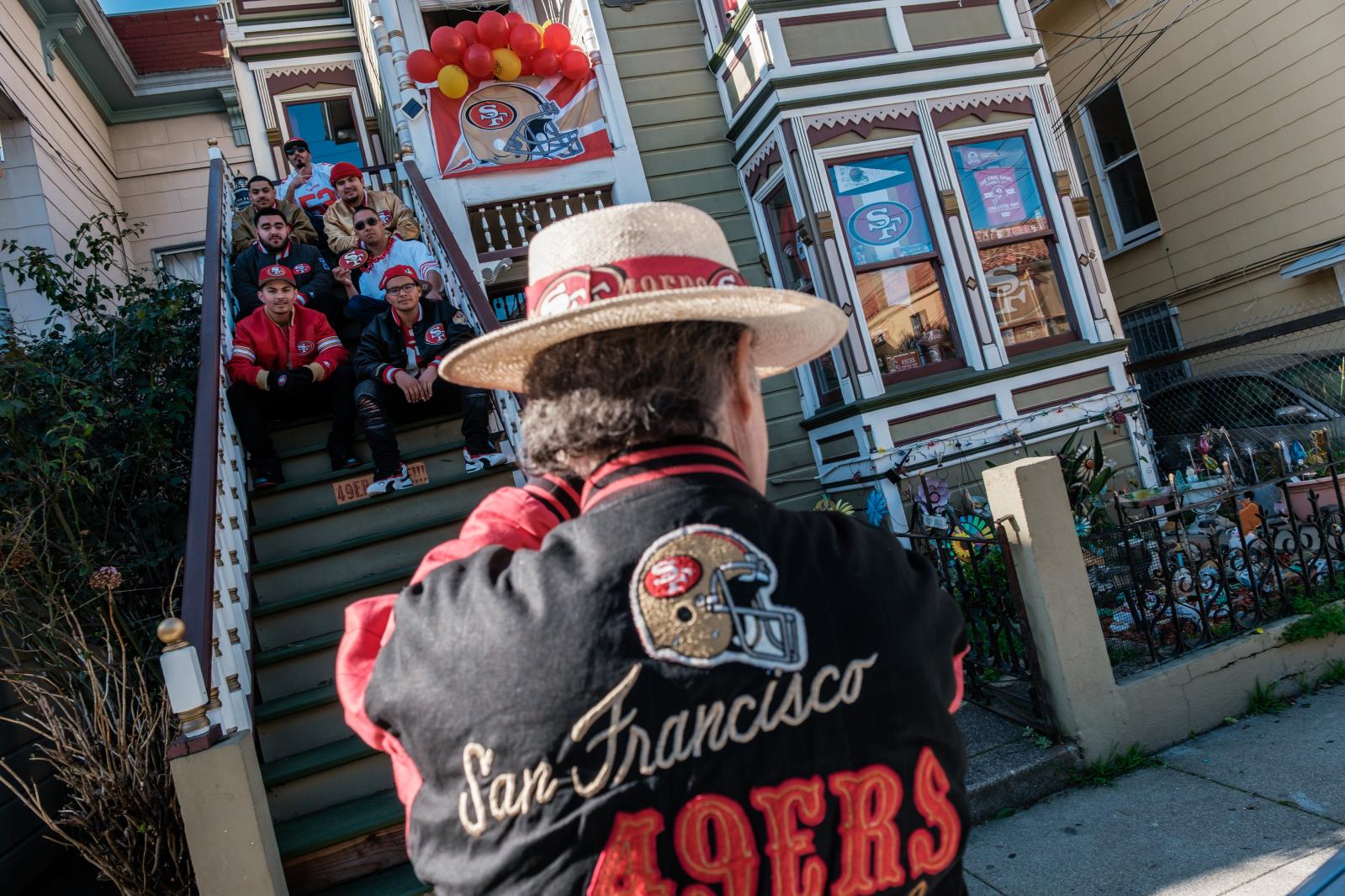 Image from A Scarlet and Gold Neighborhood - A man takes photographs of his neighbors on the steps of...