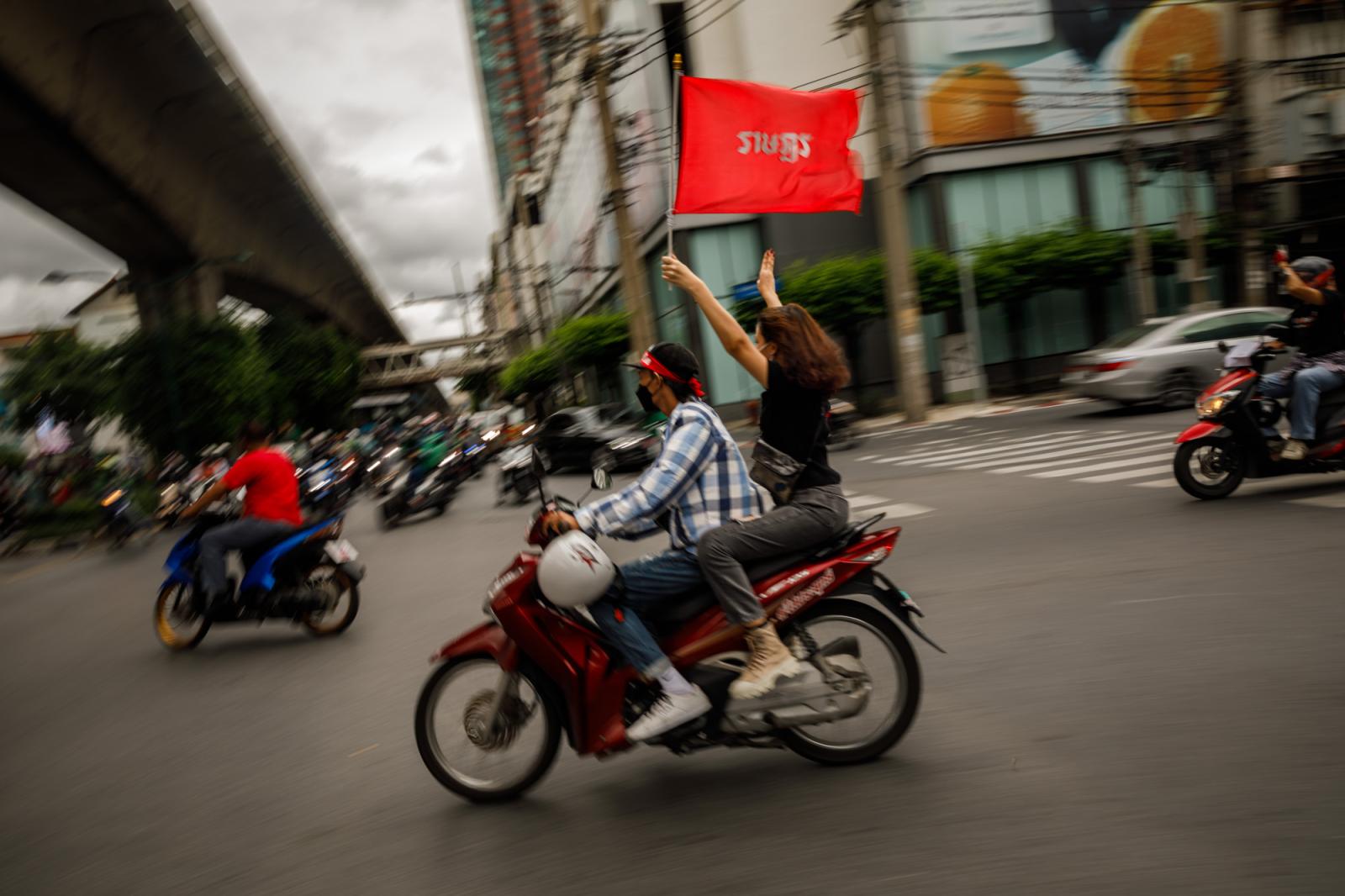 A pro-democracy protestor holds...into a constitutional monarchy.