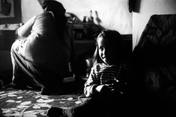 Image from Kobane in Exile - A young girl named Evlin sits inside her family's...