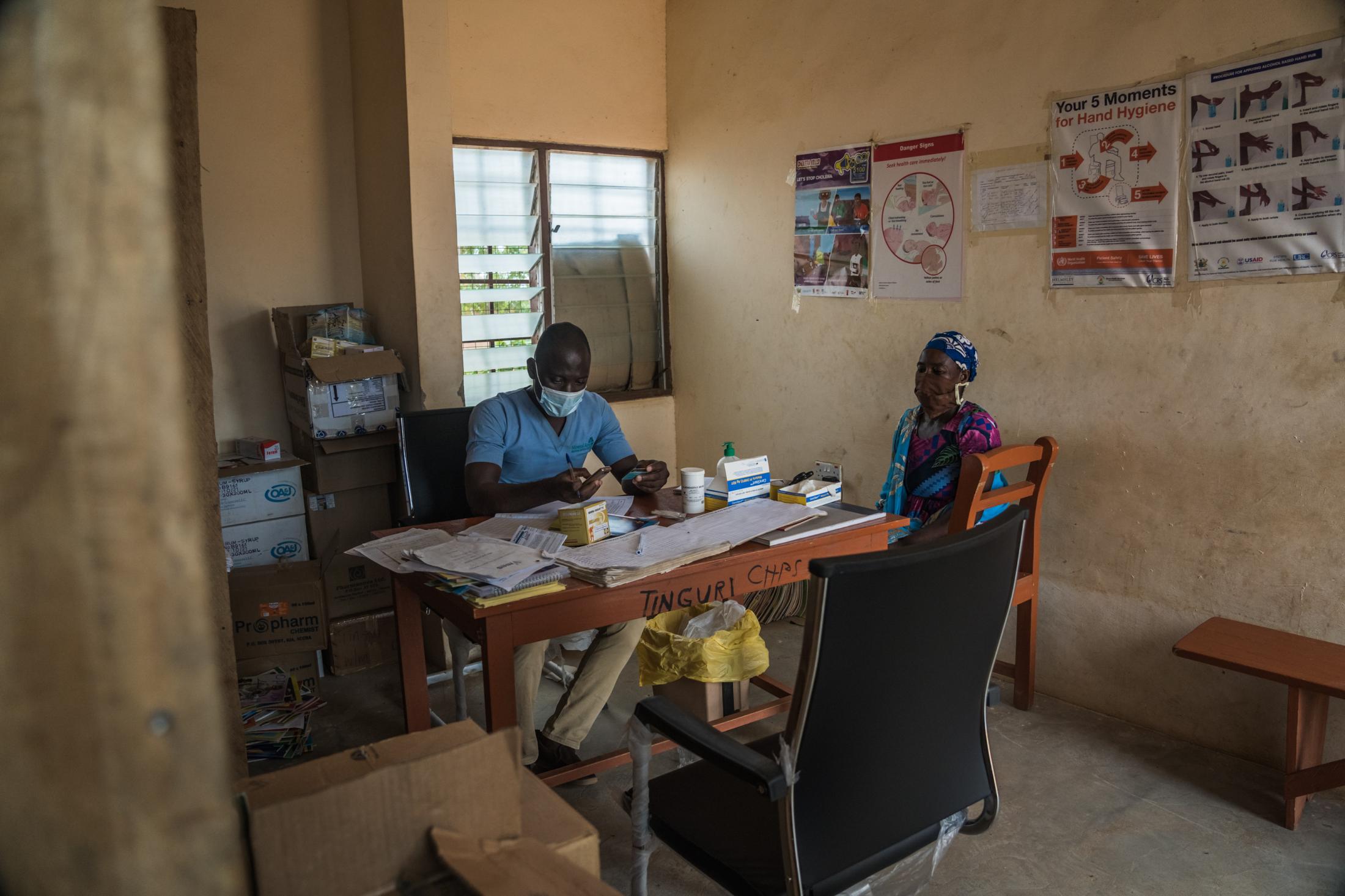 Covid-19 Response in Northern Ghana - The doctor at the Tinguri Health Clinic attends to Haija...