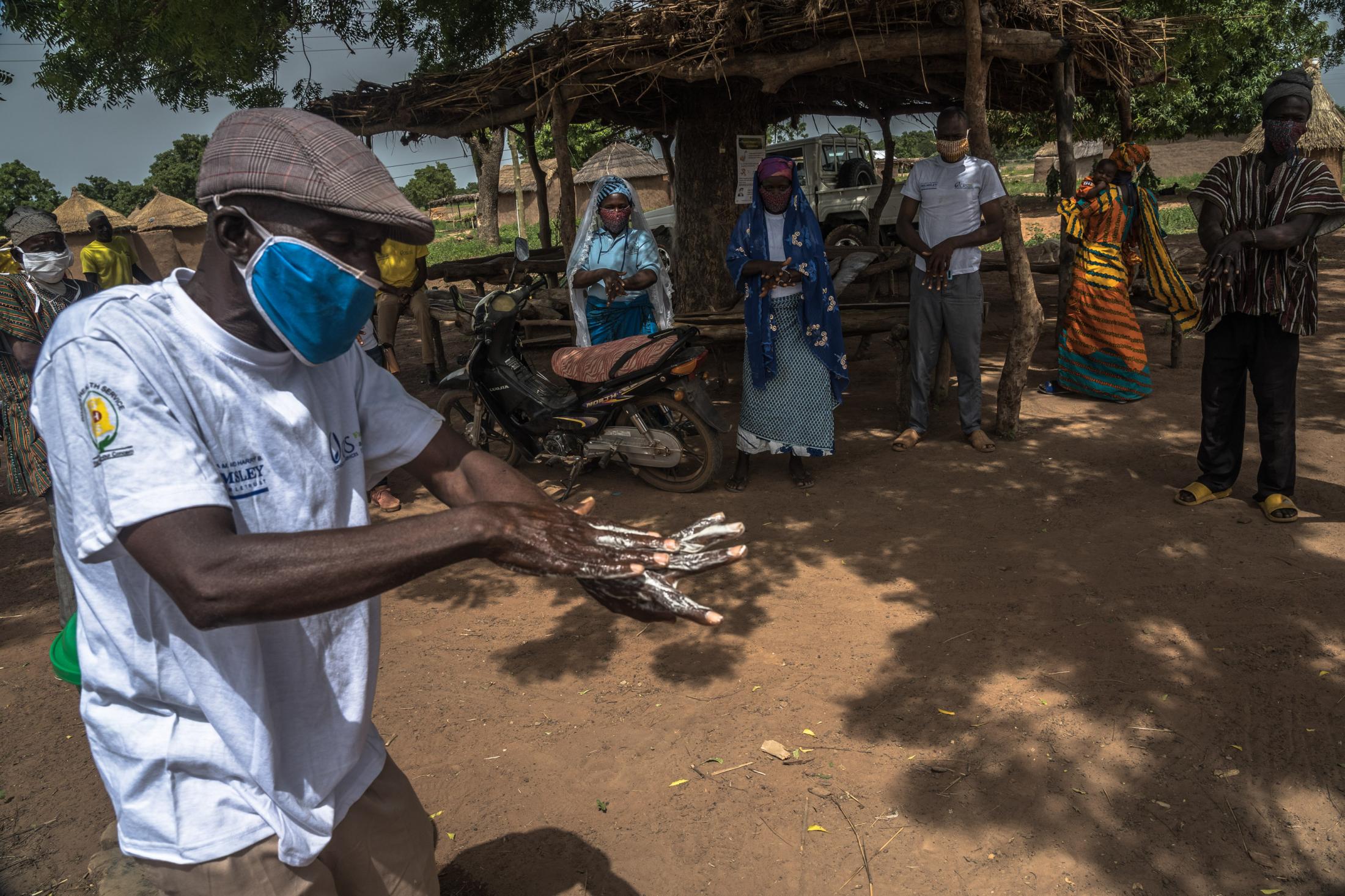 Covid-19 Response in Northern Ghana - Community volunteer Wuni Haruna demonstrates how to clean...