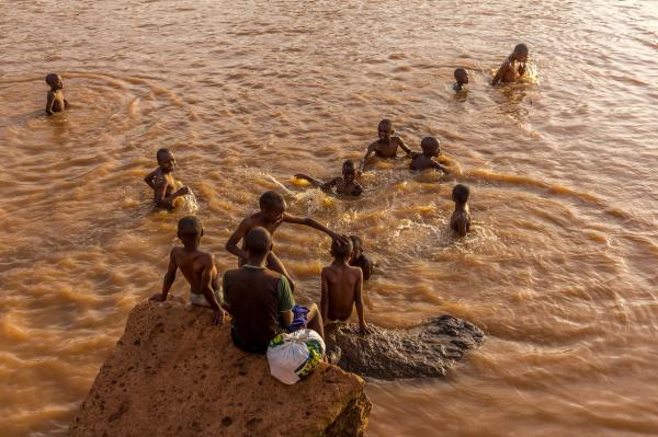 Brian Otieno | Kibera Stories - Kids swimming in the murky and obscure brown waters...