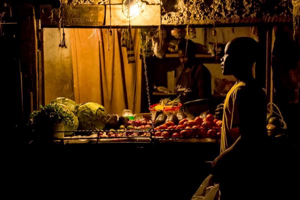 Brian Otieno | Kibera Stories - A boy shops for the night time meal at a grocery kiosk in...