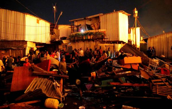 Thomas Mukoya | A Spectacular Failure - Residents gather near their salvaged belongings as their...