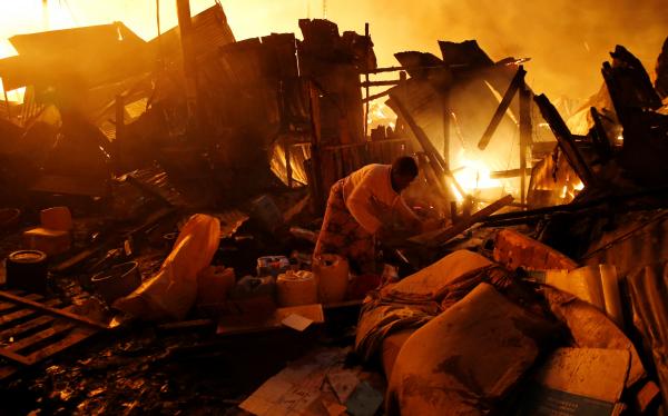 Thomas Mukoya | A Spectacular Failure - A resident attempts to salvage belongings as houses burn...
