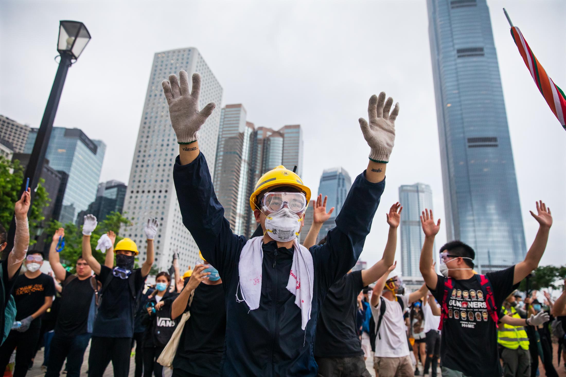  Protesters raise their hands at the police. On June 12, there were about half a million people on the streets in a protest that surrounded LegCo to prevent deputies from entering to discuss the extradition bill. Law enforcement officials respond with batons, pepper spray and tear gas to disperse the protesters. 