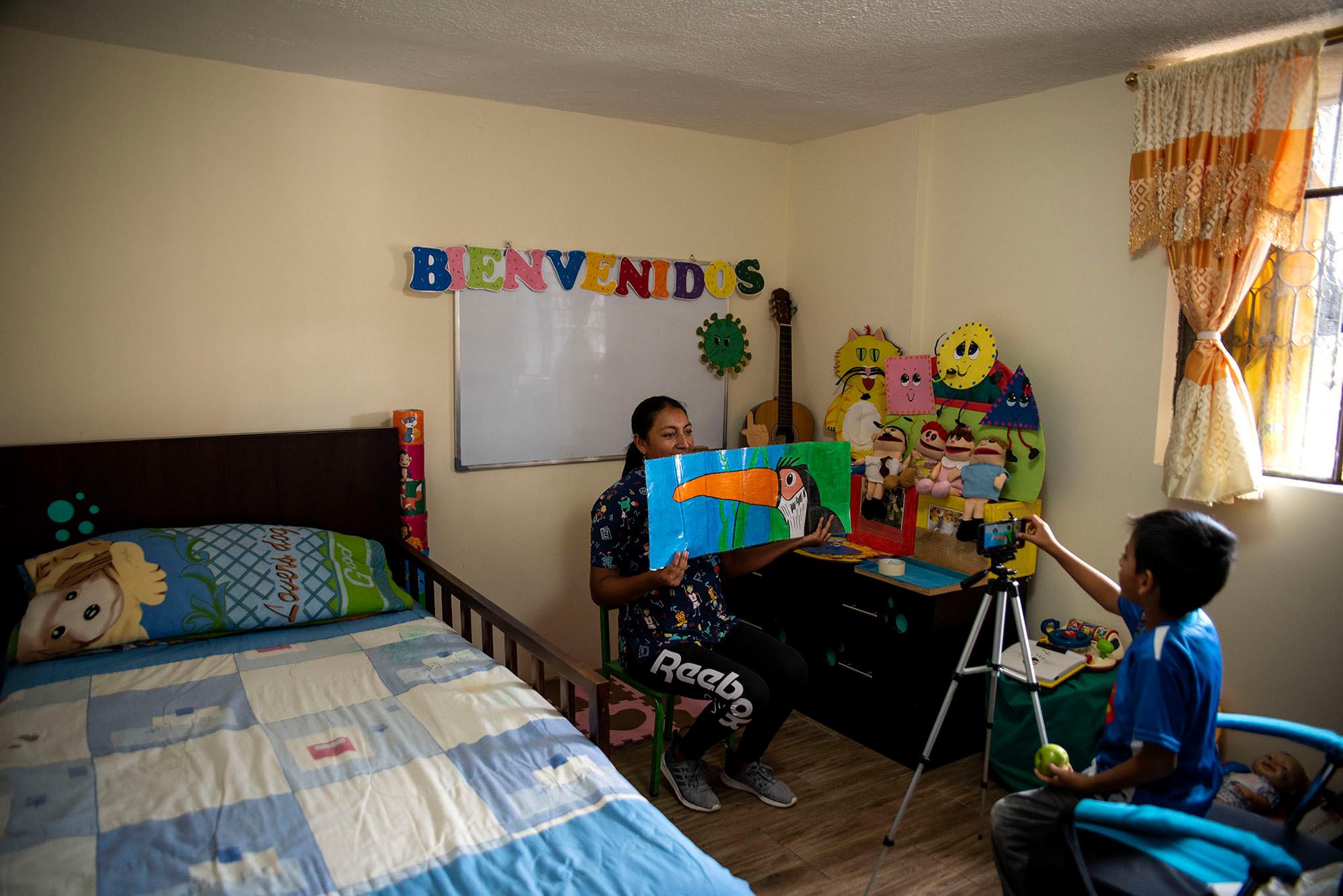 Graciela Almachi is a teacher who has to practice virtual education. She is recording a class-video with the help of her 6-year&acute;s son in a makeshift classroom at home. Quito, June 22, 2020. Johis Alarc&oacute;n