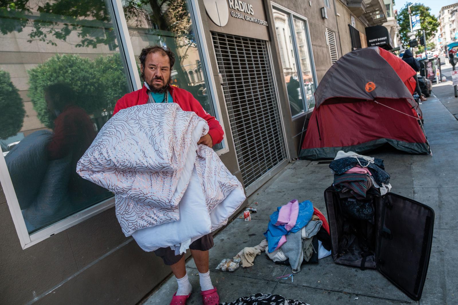 Image from San Francisco's Housing Crisis - Eric Delahonssaye organizes his belongs near a small tent...
