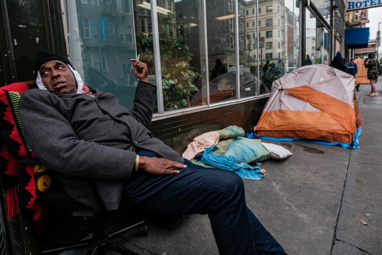 Image from San Francisco's Housing Crisis - Charles Johnson, a homeless man, sits on the sidewalk...