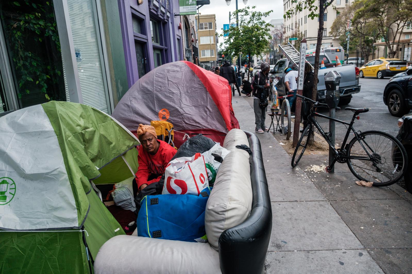 Image from San Francisco's Housing Crisis - People are seen near a row of tents in the Tenderloin in...
