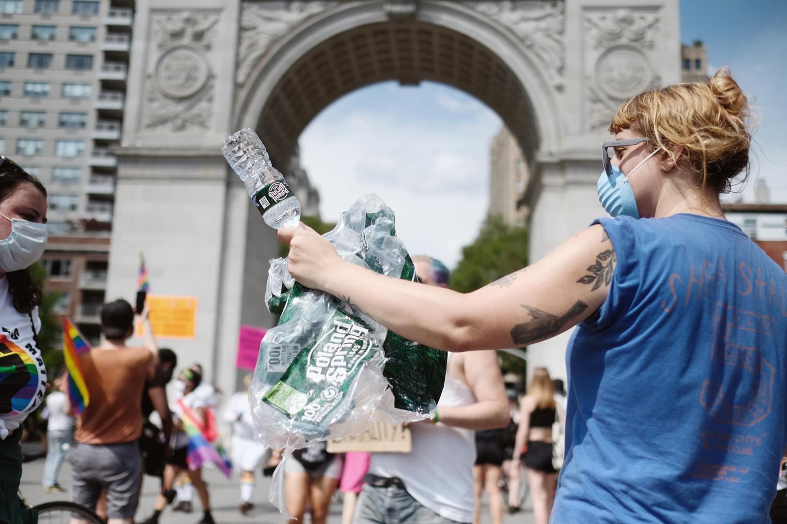 Volunteer hands out water bottl...test in Washington Square Park.