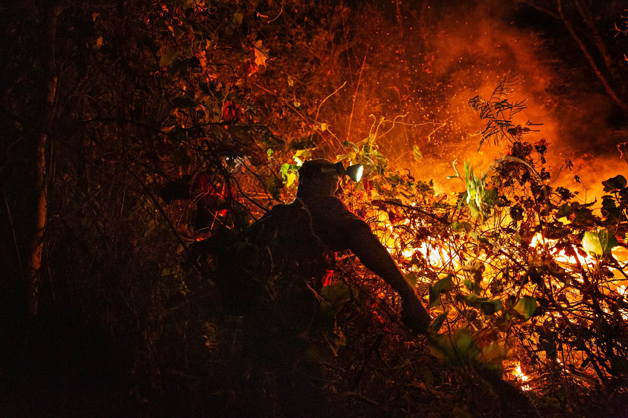 A fire fighter from Doi Mae Salong fire station works to put out a forest fire near Thai-Myanmar border, April 2019. The part-time hires worked day and night to keep the blazes in check.