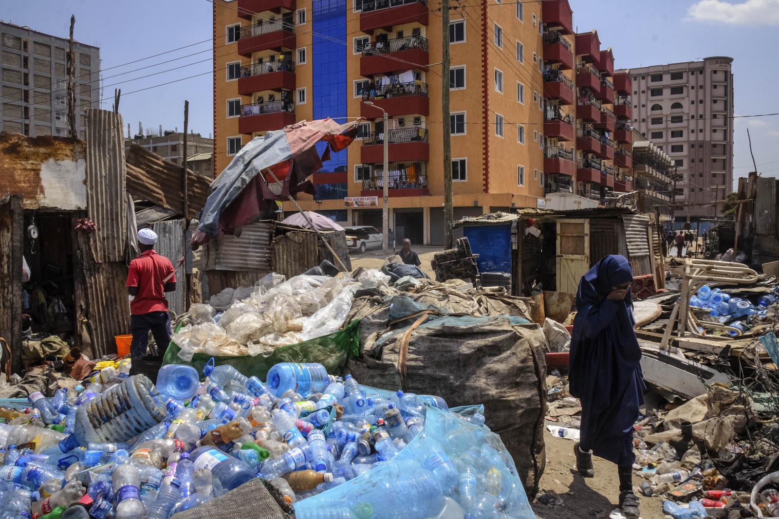 A girl walking in between plastic wastes, and bottles at a collection center in Eastleigh a...