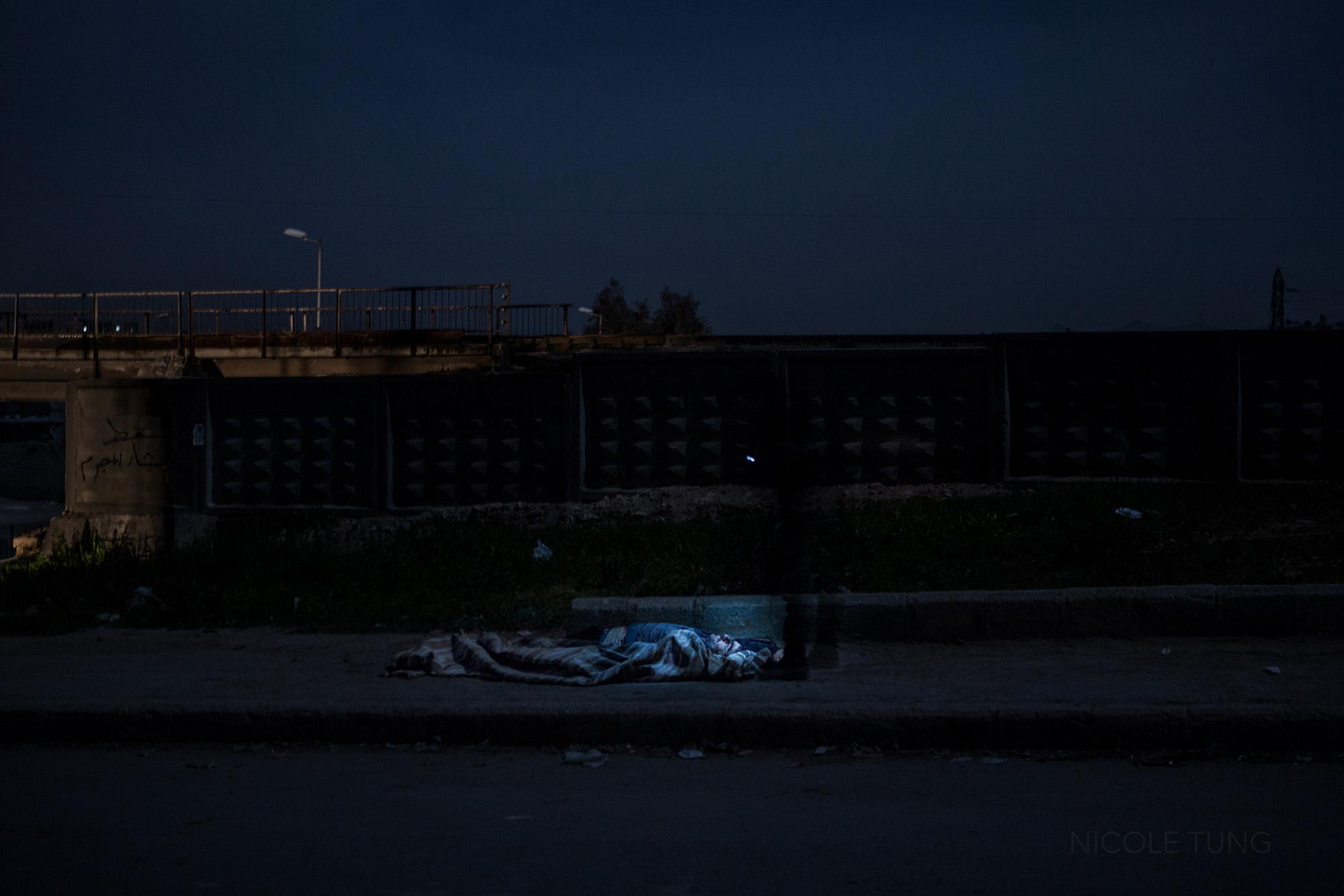 Syria: The Long Night - A dead government soldier lays by the side of the road,...