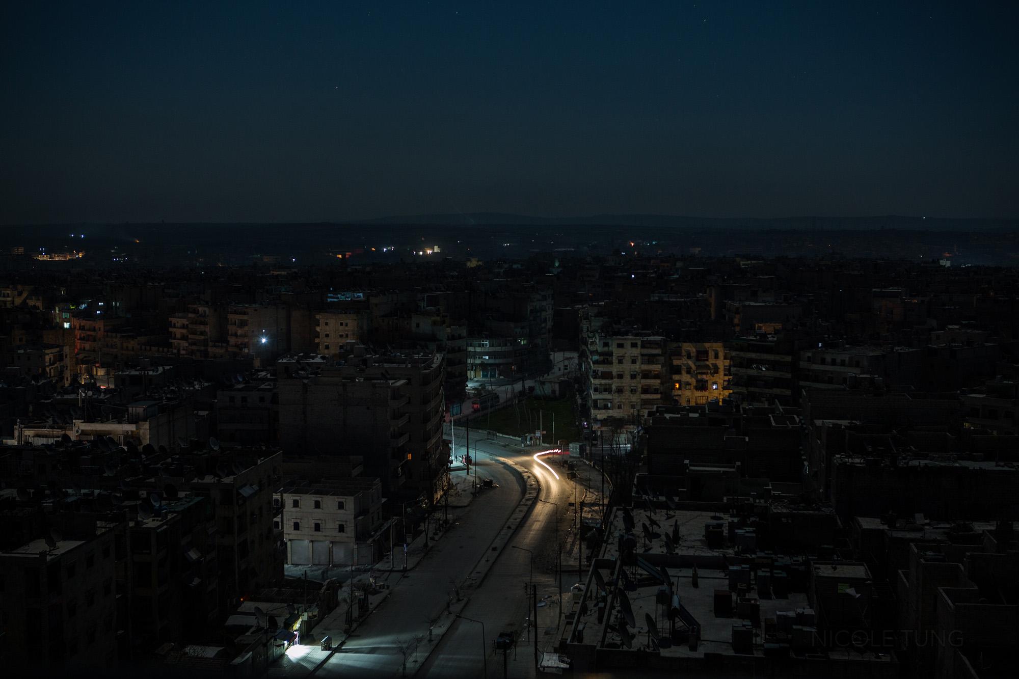 A street is briefly lit by car headlights near the Al Sukkari neighborhood of Aleppo, Syria....