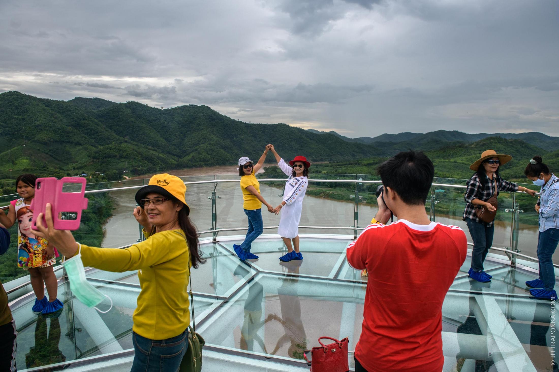 The new glass skywalk of Chiang Khan province is located at a joined border point between Thailand and Laos. This tourist attraction allows for beautiful views of the Mekong River running into Thailand from Laos. The Sanakham Dam site is planned only 2 km away from the border. In Loei, Thailand &ndash; August 2020.